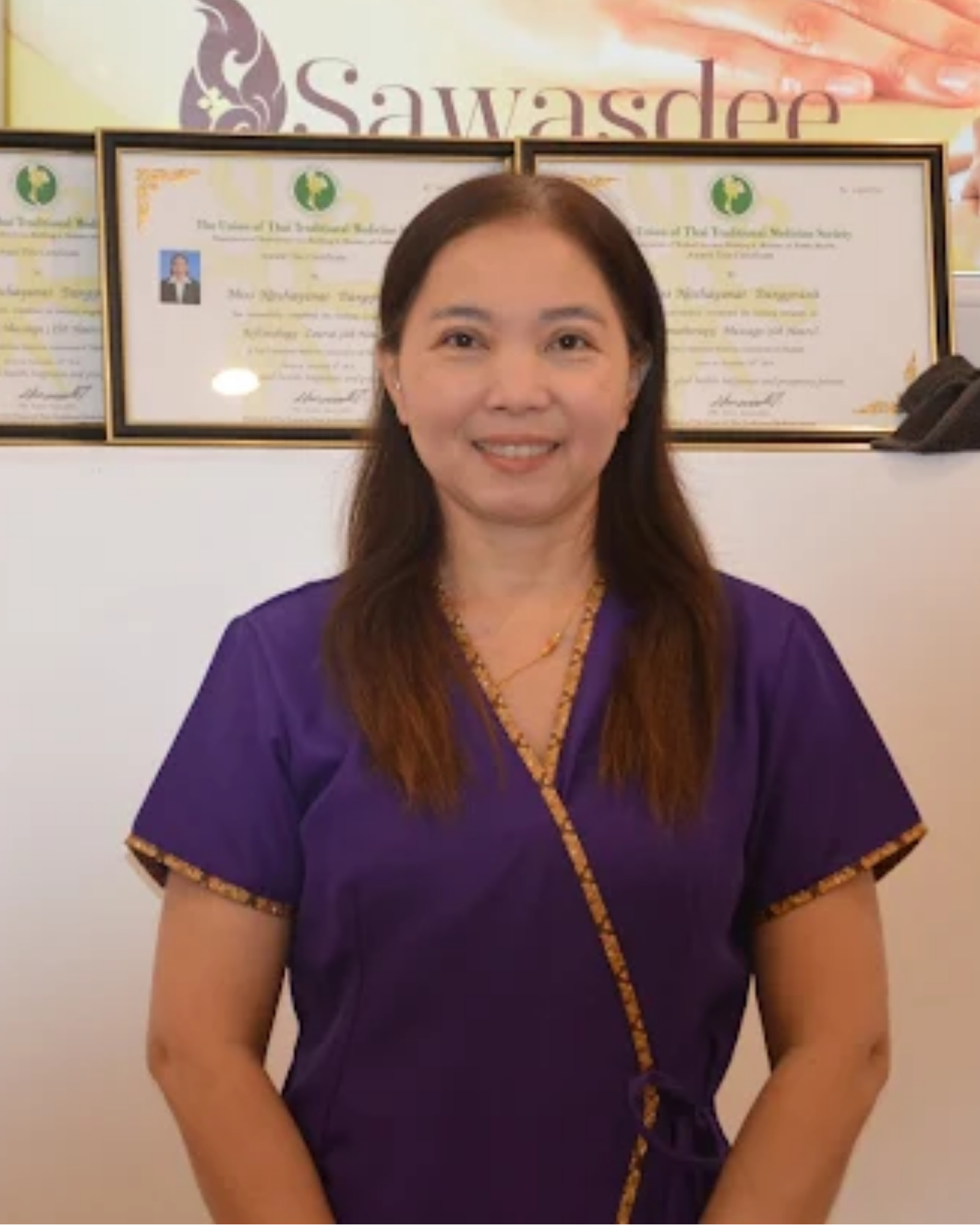 La praticienne Sawasdee devant ses certificats